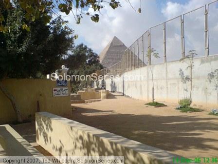 Modern graveyard entrance at the the foot of the pyramids.  Note the wall that blocks view for any tourists who may go astray.  Note the graves above 