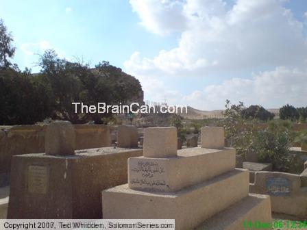 Large bluff near burial sites very near the location of the pyramids at Giza.  Graves in fore ground are above ground because the water table is too h